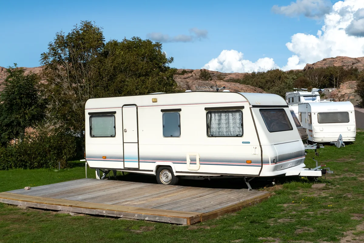 White single-axle caravans parked on grass pitches at a campsite